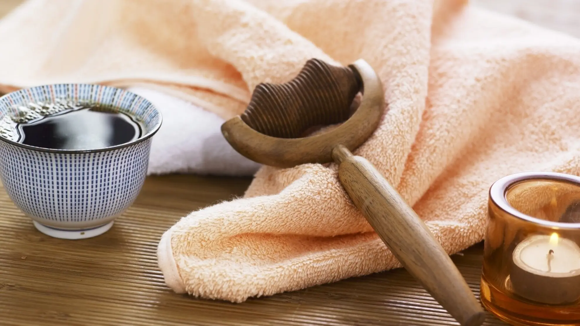 Wellness Massagerolle Handtuck Teeschale und Teelicht Adobe Stock 1051942