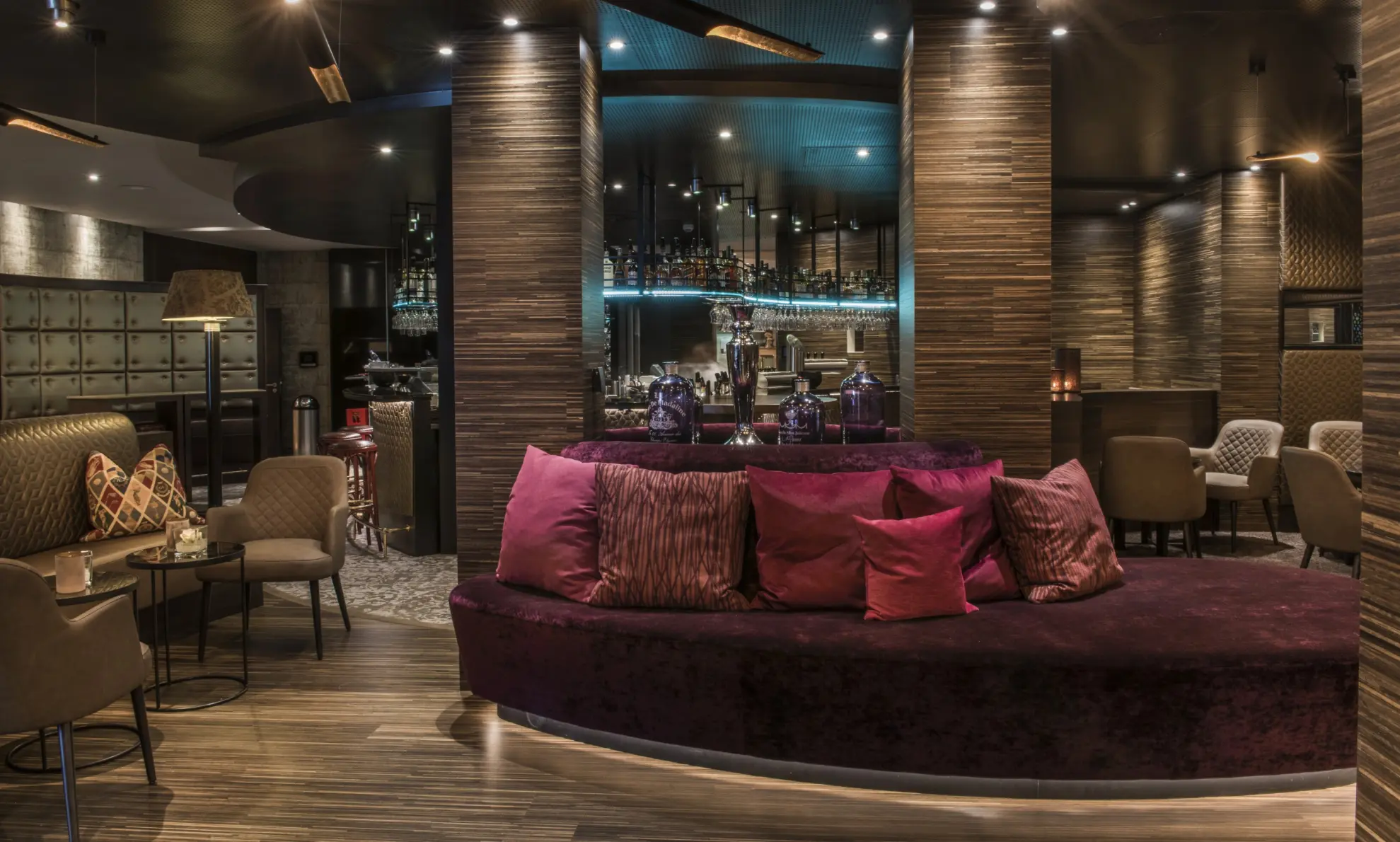 Hotelbar Birdie in Abendstimmung beleuchtet Lounge mit Sofas roten Kissen mit Blick zur Bar 1