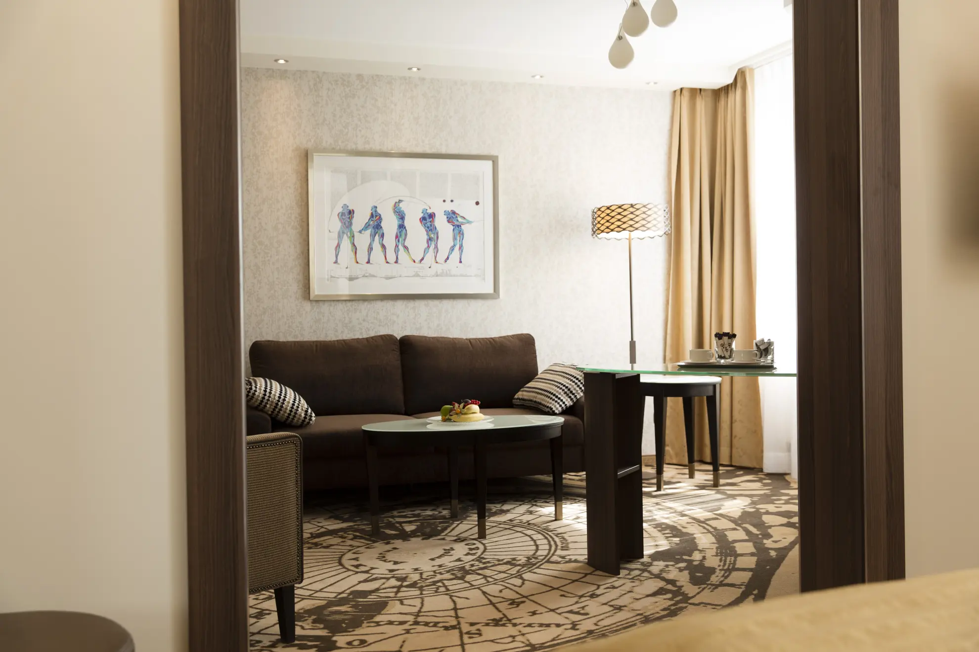 Juniorsuite in Beigetoenen mit Couch und Teppich mit Globus Motiv 2