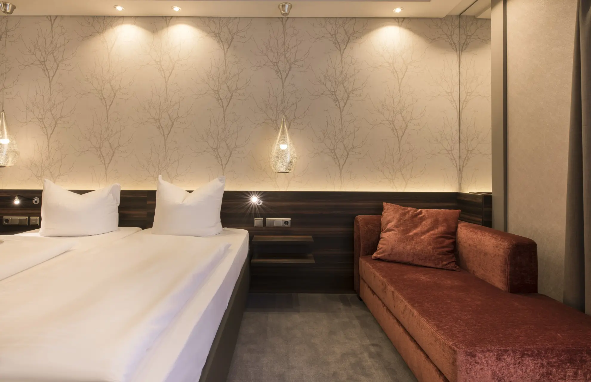 Komfort Doppelzimmer mit Doppelbett und heller Tapete mit Zweigen 1