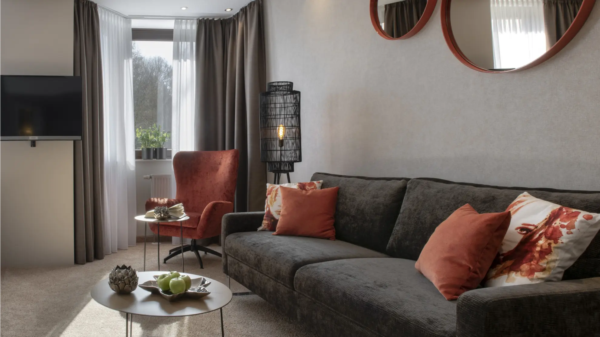 Komfort Plus Doppelzimmer mit Tisch Couch runde Spiegelrahmen und helle Tapete