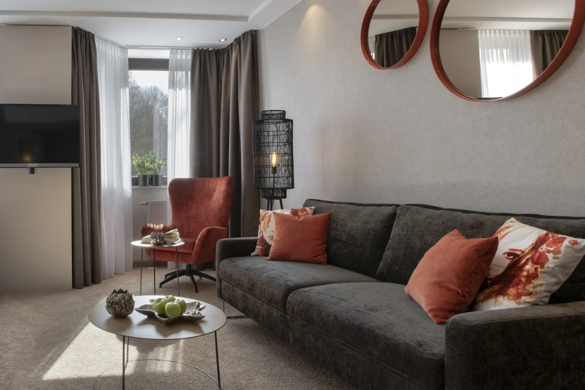 Komfort Plus Doppelzimmer mit Tisch Couch runde Spiegelrahmen und helle Tapete