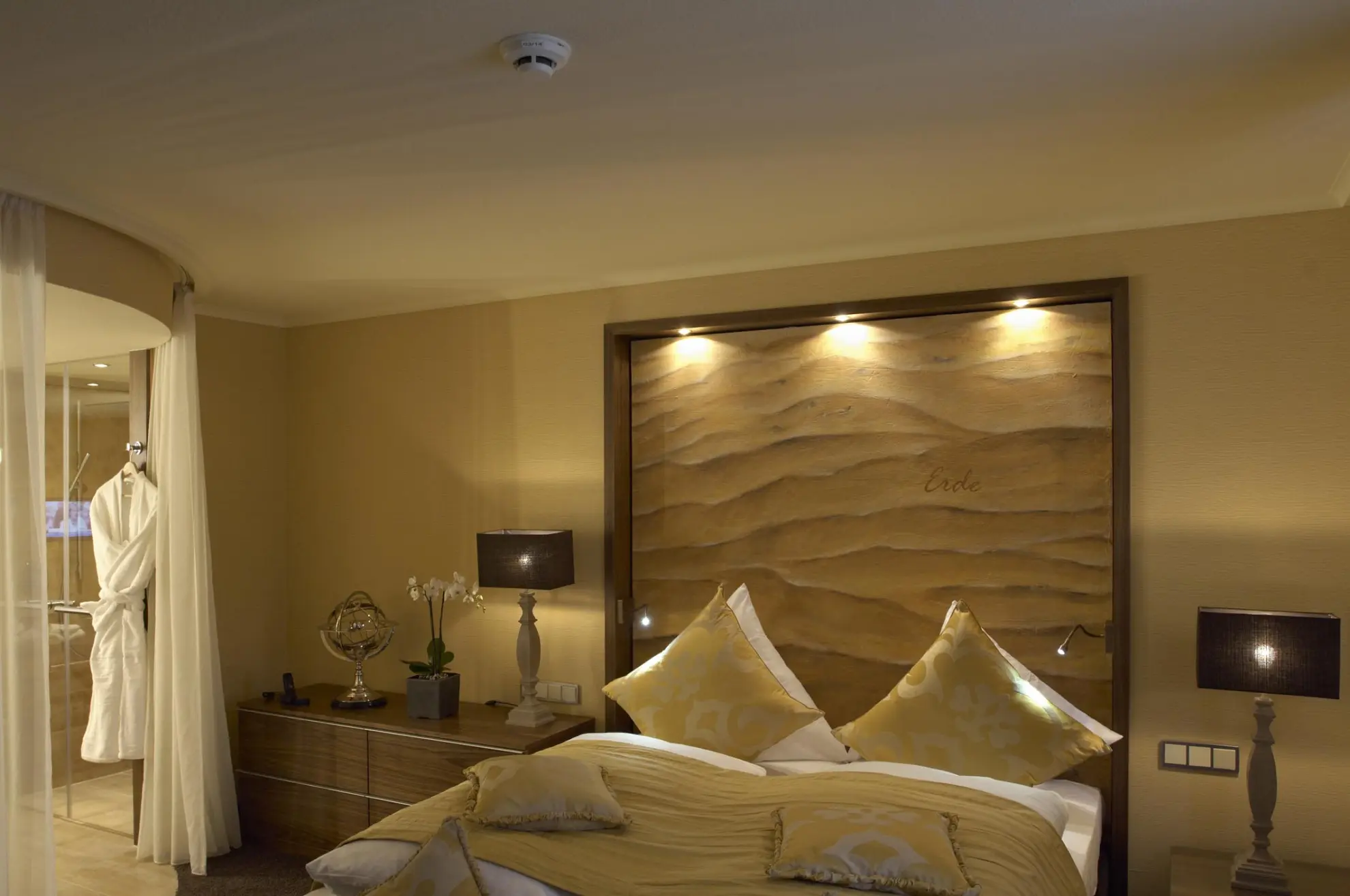 Superior Suite Erde mit Doppelbett Goldener Tagesdecke und Wandpanel